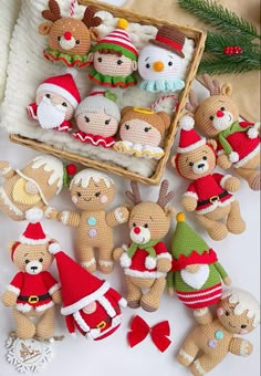 small crocheted teddy bears in christmas outfits next to a basket filled with other stuffed animals