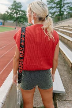 Gear up for game day with this red knit top featuring an embroidered "gameday" design in black. Show off your team spirit for the ULL Rajin' Cajuns with this sleeveless, stretchy top perfect for tailgates and football games. Get ready to cheer your team to victory in style! runs true to size with a roomie fit stretchy model, Kylee is wearing a size small Team Spirit Red Sleeveless Tops, Red Sleeveless Tops For College, Red Sleeveless College Tops, Collegiate Red Sleeveless Top, Red Collegiate Sleeveless Top, Casual Sleeveless Tops For Game Day, Sleeveless Varsity Top For Game Day, Trendy Red Top For Game Day, Trendy Red Tops For Game Day