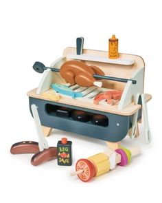 an image of a toy kitchen set with food in the oven and cooking utensils