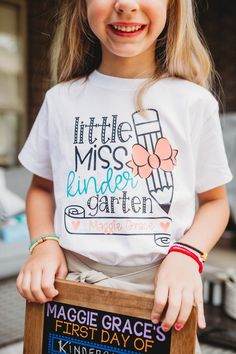 "Head back to school in a super cute school shirt personalized just for you!! This adorable design is sure to be a big hit with your little Miss on the first day of school. Our soft, light-weight cotton/poly tees are a must-have for this Fall. Available in Pre-K through 6th Grade. ITEM DETAILS 1 - \"Little Miss - Personalized\". UNISEX TEE or RAGLAN. * Bow, hearts, and names are applied in peach shimmer vinyl on the White/Heather Peach. * Bow, hearts, and names are applied in coral on the White School Spirit Tops With Name Print For School Events, Cute Letter Print Tops For School Events, Cute Graphic Print Tops For School Events, Cute Pre-shrunk Shirt For Back To School, School Spirit Cotton Shirt For School Events, Cotton School Spirit Shirt For School Events, Fun T-shirt For Back To School, Cute T-shirt With Name Print For Teacher Appreciation, End Of School Year Text Print Shirt