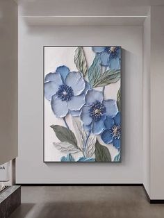 an abstract floral painting hangs on the wall in a white room with gray floors and walls