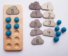 two wooden pegs with numbers and clouds next to each other on a white surface