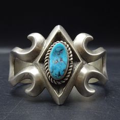 CLASSIC VINTAGE SAND CAST STERLING SILVER and TURQUOISE BRACELET DESCRIPTION:  With a gorgeous specimen of natural blue Kingman turquoise, this classic bracelet will be a cherished addition to your collection of fine vintage Southwestern and Native American jewelry. MEASUREMENTS: Interior of the cuff measures 5 1/4" with an additional 7/8" slightly adjustable gap. Total circumference:  6 1/8" Measures 2 1/8" straight across the widest part  (from wrist bone to wrist bone) Bracelet face measures Adjustable Blue Cuff Bracelet With Patina, Adjustable Blue Patina Cuff Bracelet, Classic Blue Bangle For Formal Occasions, Blue Classic Bangle For Formal Occasions, Unique Blue Cuff Bracelets, Unique Blue Cuff Bracelet For Formal Occasions, Blue Southwestern Handmade Bangle, Blue Unique Cuff Bracelet For Formal Occasion, Blue Collectible Cuff Bracelet Bangle