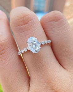 a woman's hand with a diamond ring on top of her finger and an engagement band