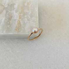 This dainty pearl ring will be handmade to order in your size.  Created with a natural 6mm white freshwater pearl, it will make a beautiful birthday gift for a July born person.  Please select the material and band width at the checkout. *Listing is for a pearl ring only. *Every pearl is unique but will closely match the featured one.  Model wears ring size 5, 1.3mm band Fine Jewelry Stackable Pearl Ring With Round Band, 14k Yellow Gold Rings With Pearl Charm, Pearl Stackable Round Rings For Anniversary, Stackable 14k Gold Pearl Ring With Round Band, Fine Jewelry Stackable Pearl Promise Ring, Pearl Drop Promise Ring, 14k Gold Filled Midi Rings For Wedding, Dainty Pearl Drop Ring For Everyday, Elegant 14k Gold Filled Stackable Rings