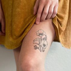 a woman's leg with a flower tattoo on her left thigh and the bottom part of her legs