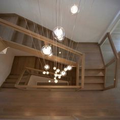 a room with some lights hanging from the ceiling and wooden stairs leading up to it