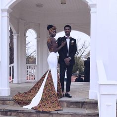 a man and woman in formal wear standing on the steps of a white gazebo