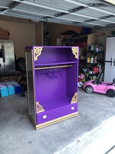 an open purple cabinet in a garage next to a pink toy car and other items