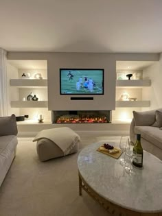 a living room filled with furniture and a flat screen tv mounted on the wall above a fireplace