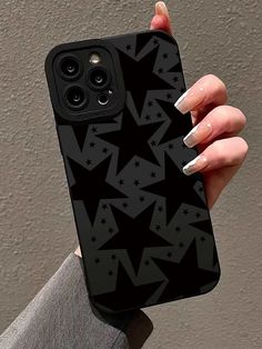 a woman's hand holding an iphone case with black stars on it