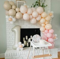 a fireplace decorated with balloons and decorations for a first birthday party or baby's first birthday