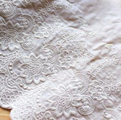 an old lace tablecloth is laying on the floor