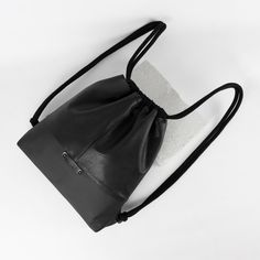 Genuine leather women's/ unisex black backpack / gymbag / drawstring leather bag. 100% recycled leather, made out of a vintage leather garment, and industrial leather waste ♻️ Absolutely unique one-of-a-kind piece.  Comfortable to wear, perfect choice for everyday use. Backpack size: Height: 37 cm (~ 14.5 inches) Width: 35 cm (~ 13.7 inches) Depth: 5,5 cm (~ 2.2 inches) Fully lined with high quality black cotton material.   Two pockets inside.:  14cm x 15cm  /5.5 x 5.9 inches/ Made with patience Casual Leather Duffle Bag Backpack, Sporty Black Leather Duffle Bag, Sporty Leather Bag With Large Capacity, Black Bucket Backpack For Travel, Functional Black Leather Backpack With Leather Handles, Casual Black Drawstring Bag With Large Capacity, Modern Black Gym Bag, Functional Leather Tote Backpack, Black Leather Backpack With Large Capacity For Everyday