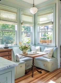 a corner table in the middle of a room with two couches and a window