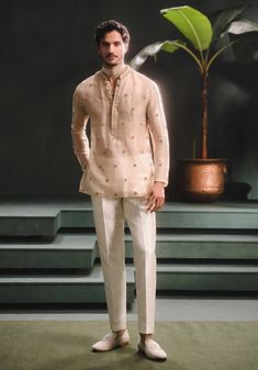 Step into refined elegance with the Kaju Katli Raja koti, an opulent sherwani adorned with intricate gold zardozi, katdana, and pearl embroidery, inspired by 'Berry Bel'. The ensemble includes a short georgette tissue kurta that adds a playful touch and straight, tailored pants for a smart finish. This piece is a perfect blend of grandeur and modern sophistication. Sherwani Style Kurta For Mens, Wedding Attire Men Casual, Men Indian Outfits, Mens Kurta Collar Designs, Men’s Short Kurta, Men’s Kurta Style, Kurta With Embroidery For Men, Boys Outfits For Wedding, Wedding Wear For Men Indian