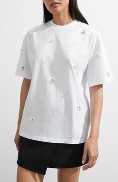 Sparkly, embellished flower appliqués add textural elegance to this boxy T-shirt made from soft cotton. 26" length Crewneck Short sleeves 100% cotton Dry clean or machine wash, dry flat Made in Turkey Embellished Cotton Short Sleeve T-shirt, White Short Sleeve Top With Floral Applique, Cotton Embellished Short Sleeve T-shirt, White Floral Applique Short Sleeve Top, Casual Embellished Crew Neck T-shirt, White Short Sleeve T-shirt With Floral Applique, Summer Crew Neck T-shirt With Floral Applique, White Crew Neck Top With Floral Applique, Floral Applique Crew Neck T-shirt For Summer