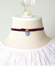 This stunning choker necklace is handmade with a soft velvet ribbon in a deep eggplant purple hue. It features a velvet bow, a pearl beaded jewel and an eye-catching faceted blue heart charm. A one-of-a-kind gift for women and girls. * Size ~ Adjustable length 12 - 15 inches with extender chain  Please check your neck size carefully as I do not accept returns or exchanges on these necklaces. Contact me prior to purchase. I am happy to adjust the size for you if possible. * 1/4 inch wide velvet b Purple Choker, Velvet Choker Necklaces, Velvet Choker, Beaded Jewels, Pearl Choker Necklace, Velvet Bow, Pearl Choker, Pretty Gift, Blue Heart