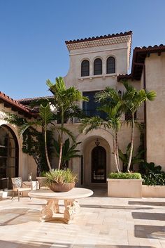 a large house with palm trees in the courtyard