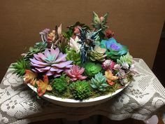 a bowl filled with succulents on top of a table