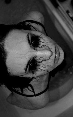 black and white photograph of a woman in a bathtub with her face covered by hair