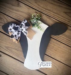 a cow with a bow on it's head is sitting on a wooden table