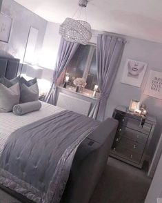 a bed room with a neatly made bed and a chandelier