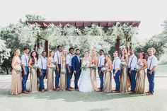 a group of people standing next to each other in front of a tree filled field