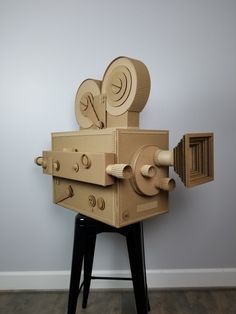 a cardboard robot sitting on top of a stool