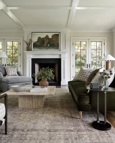 a living room filled with furniture and a fire place in front of a fireplace surrounded by windows