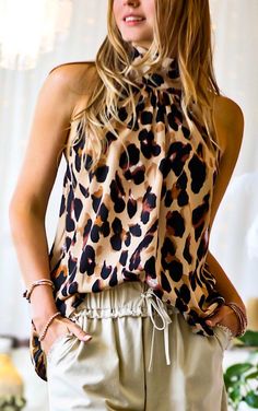 We have never met a leopard print we don’t love… this one is no exception! This is a super luxe looking leopard print on a gorgeous caramel background in a halter style top with a  relaxed fit that looks super cute tucked or untucked! Wear it more casually with shorts in warmer months, then add black jeans or leather p Caramel Background, Leopard Print Top, Halter Style, Strapless Bra, Print Top, Print Tops, One Shoulder Blouse, Leather Pants, Leopard Print