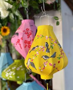 several colorful umbrellas are hanging in the air with flowers and leaves on them,