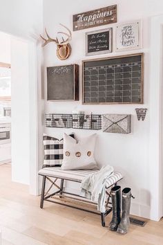 a white bench sitting in the middle of a room next to a wall with pictures on it