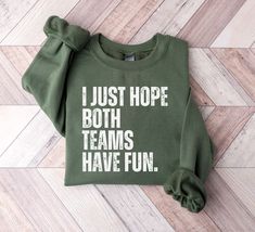 I Just Hope Both Teams Have Fun Sweatshirt, Tailgating Tops, Football Party Sweatshirt, Go Sports Sweatshirt, Yay Sports Crewneck Sweatshirt These Sweatshirts are Adult Unisex. -Sweatshirt Unisex Heavy Blend™ Crewneck Sweatshirt - Runs true to size - Loose fit - 50% Cotton; 50% Polyester (fibre content may vary for different colors) - Medium fabric (8.0 oz/yd² (271.25 g/m - Sewn in label - Without side seams: Knitted in one piece using tubular knit, it reduces fabric waste and makes garment more Crew Neck Tops With Slogan For Sports Season, Green Casual Tops For Team Events, Casual Green Top For Team Events, Green Graphic Print Tops For Team Events, Green Tops For Fall Sports Events, Green Crew Neck T-shirt For Team Events, Green Crew Neck Top For Team Spirit, Green Crew Neck Top With Team Spirit Style, Crew Neck Top For Team Events And Sports Season