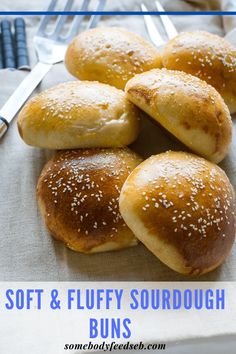 soft and fluffy sourdough buns with sesame seeds in the middle on a table