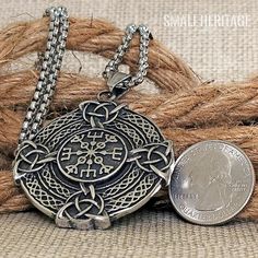 a silver coin sitting next to a rope on top of a piece of cloth with the word, small heritage