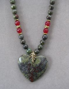 This is a lovely medium sized Heart Shaped Green and Red African Bloodstone Pendant Necklace. It is 16 inches long and adjustable to 21 inches with a lobster clasp and chain. The pendant measures 1 3/4 inches long and wide. The beads in the chain are genuine bloodstone and match the pendant stone with red crystal beads and gold accent beads.    All my jewelry is unique and one of a kind. Similar quality jewelry is priced at double. I source the stone pendants from all over the world. All pendant Spiritual Gemstone Beads Jewelry For Valentine's Day, Adjustable Heart-shaped Gemstone Beads Jewelry, Adjustable Heart-shaped Gemstone Bead Necklace, Heart-shaped Healing Necklaces With Natural Stones, Heart-shaped Beaded Necklaces With Natural Stones For Gift, Heart-shaped Beaded Necklaces With Natural Stones, Heart-shaped Natural Stones Necklaces For Jewelry Making, Heart-shaped Natural Stone Beaded Necklace For Gift, Heart-shaped Beaded Necklace With Natural Stones For Gift