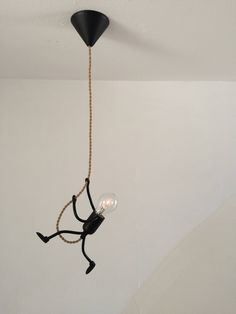 a black light hanging from the ceiling in a room with white walls and flooring