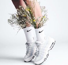 a woman's legs with flowers and nike sneakers