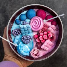 a bowl filled with different colored desserts and marshmallows on top of each other