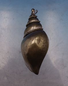 a metal object hanging from the side of a wall in front of a blue sky