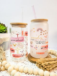 two mason jars sitting next to each other on a doily with beads and succulents