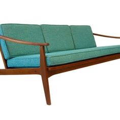 a teal colored couch sitting on top of a wooden frame