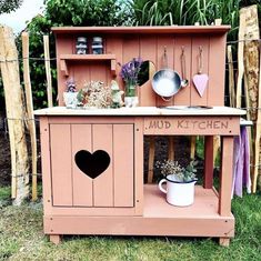 a pink wooden kitchen with pots and pans on it