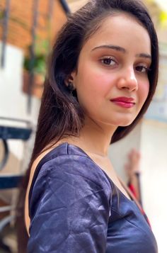 a woman with long hair is looking at the camera