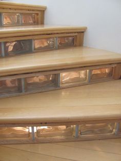 a set of wooden stairs with glass inserts on the bottom and bottom treads