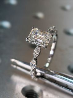 a diamond ring sitting on top of a piece of metal