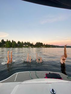 three people swimming in the water on a boat