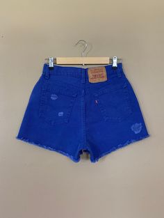 "High waisted 90's denim shorts. Made by Levi's in rare bright blue denim wash. Shorts are in excellent clean condition. Brand new with tags before I made them into cutoff shorts. These have been cutoff, distressed by hand, and washed once. Measurements are taken zipped or buttoned up and laid comfortably flat then x 2 for total circumference (inches) Tag Size 7 Levi's 560 100% Cotton Made in USA Waist 28\" Hips 42\" Length 13.5\" Inseam 2.5\" Rise 12\" leg opening circumference 26\" All items a 90s Washed Blue Relaxed Fit Bottoms, 90s Style Washed Blue Relaxed Fit Bottoms, 90s Style Washed Blue Bottoms With Relaxed Fit, 90s Style Relaxed Fit Washed Blue Bottoms, 90s High Waist Dark Wash Bottoms, Blue Distressed Cotton Shorts, Blue Retro Bottoms With Frayed Hem, Cutoff Denim Blue Shorts With Belt Loops, Retro Cutoff Bottoms For Summer