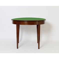 a small table with a green top on it's legs, against a white background